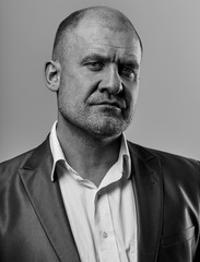  Serious angry man in suit looking. Portrait of actor on grey background. Emotional natural portrait. Closeup.