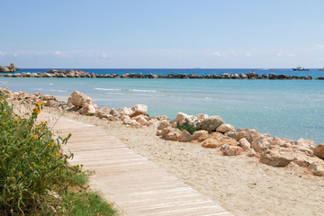 Fototapeta na wymiar passerella di legno con sfondo mare sulla costa - Otranto