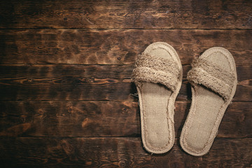 Bath slippers on a wooden floor background with copy space.
