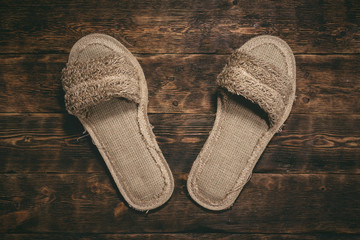 Bath slippers on a wooden floor background.