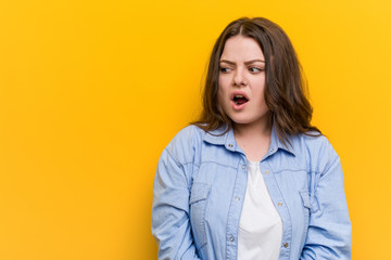 Young curvy plus size woman being shocked because of something she has seen.