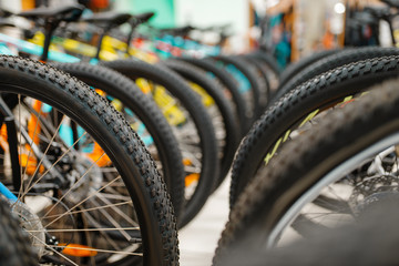 Rows of cycles in sports shop, focus on wheels
