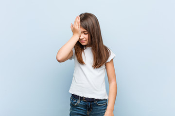 Cute girl forgetting something, slapping forehead with palm and closing eyes.