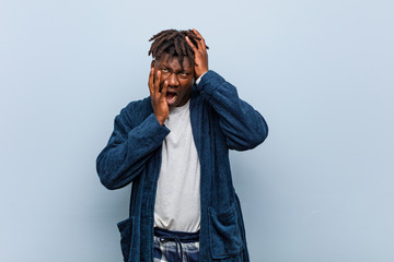 Young african black man wearing pajama whining and crying disconsolately.