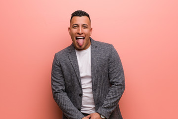 Young elegant latin man funnny and friendly showing tongue