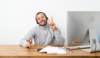 Telemarketer Colombian man showing victory sign with both hands