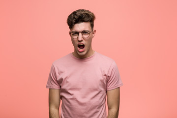 Young cool caucasian man screaming very angry and aggressive.