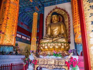 Fototapeta na wymiar Golden buddha statue in Tianmen Temple Hall on tianmen mountain zhangjiajie city China.Tianmen Temple is on the top of Tianmen mountain and landmark of zhangjiajie city china