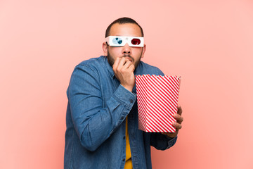 Colombian man with popcorns is a little bit nervous and scared