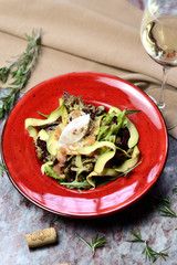 salad with salmon, avocado and capers on a red plate