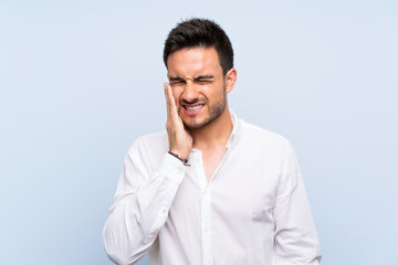 Handsome young man over isolated blue background with toothache