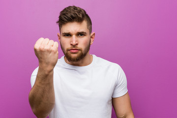 Fototapeta premium Young handsome caucasian man showing fist to camera, aggressive facial expression.