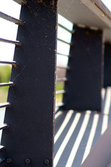 .Die Nahaufnahme eines Gehweges auf einer Brücke dessen Geländer symmetrische Schatten wirft...