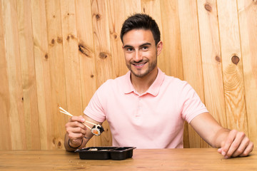 Handsome young man in a kitchen with sushi