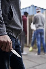 Close Up Of  Teenage Boy In Urban Gang Holding Knife