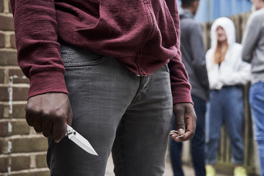 Close Up Of  Teenage Boy In Urban Gang Holding Knife