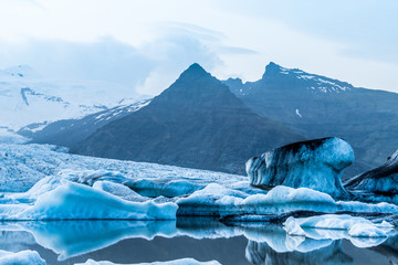 Glacier lake with icebergs with mountain and glacier in the background in Fjallsárlón, Iceland