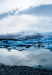 Glacier lake with icebergs with mountain and glacier in the background in Fjallsárlón, Iceland