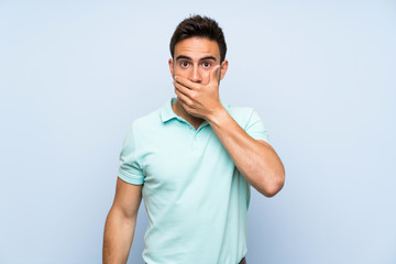 Handsome young man over isolated background covering mouth with hands