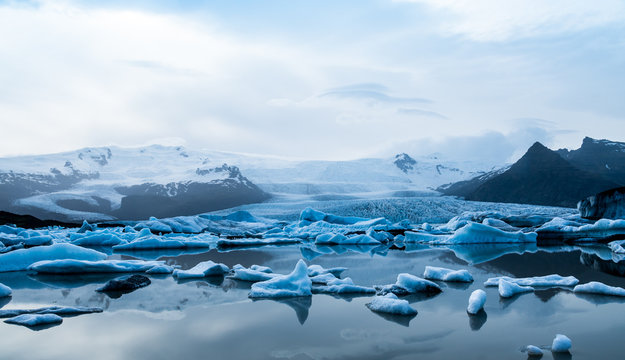 Glacier lake with icebergs with mountain and glacier in the background in Fjallsárlón, Iceland - Powered by Adobe