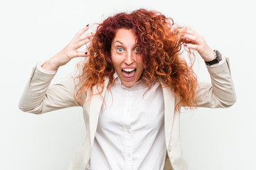 Fototapeta premium Young natural redhead business woman isolated against white background celebrating a victory or success, he is surprised and shocked.