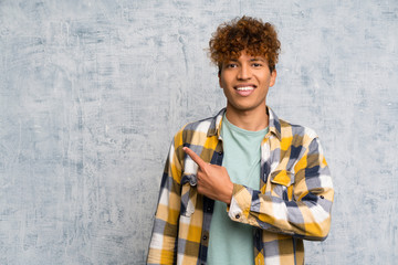 Fashion african american over grunge wall pointing finger to the side