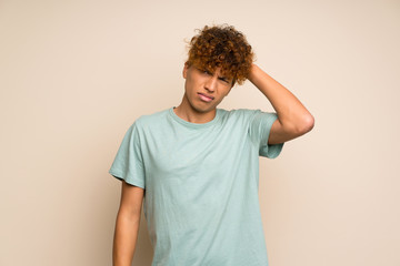 African american man with green shirt with an expression of frustration and not understanding