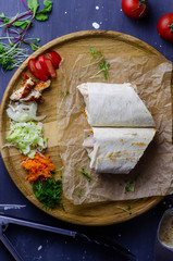 Homemade shawarma / burrito / chicken roll with vegetables and sauce. Top view ingredients