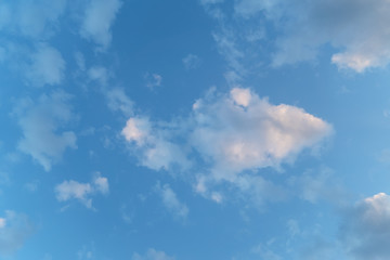 Blue sky with clouds in the form of fish and human face close up