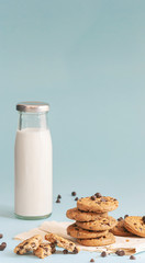 Cookies with chocolate chips and fresh milk bottles on the ground, light blue pastel colors