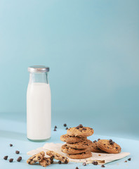Cookies with chocolate chips and fresh milk bottles on the ground, light blue pastel colors
