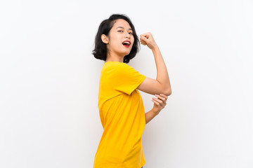 Asian young woman over isolated white background doing strong gesture