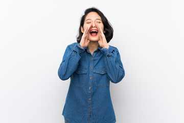 Asian young woman over isolated white background shouting and announcing something