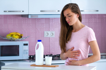Stressed sad unhappy woman suffering from milk allergy and having upset, abdominal pain from...