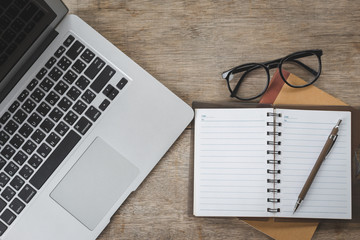 Top view of Laptop, Pen, notebook, glasses on table