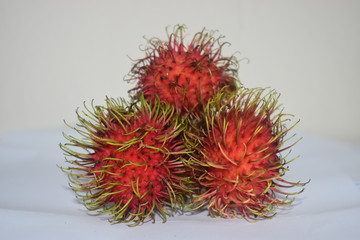 Fresh red rambutans fruit on white colour background 