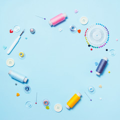 Sewing supplies, pattern and accessories for needlework on blue background, stitching, embroidery. space for text. flat lay, top view. Sew background. Dressmaker and designer desk