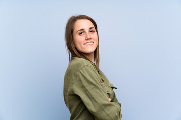 Young woman over isolated blue wall laughing