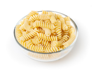 Uncooked fusilli pasta in glass bowl isolated on white background with clipping path