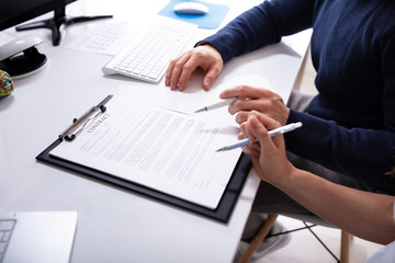 Two Businesspeople's Hand With Contract Agreement