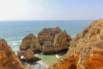 Fototapeta na wymiar Beautiful golden cliffs and emerald water in Ponta da Piedade, Lagos, Algarve, Portugal