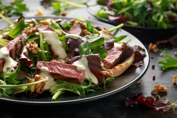Grilled Beef Steak salad with pears, walnuts and greens vegetables and blue cheese sauce. healthy food.
