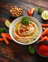 Hummus with olive oil, paprika, lemon and carrot.
