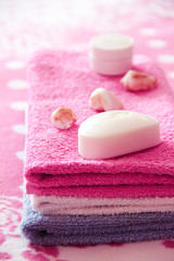 Obraz na płótnie Canvas white toilet soap and decor against the background of pink terry towels