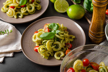 Homemade pasta with fresh basil pesto and tomatoes