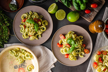 Homemade pasta with fresh basil pesto and tomatoes