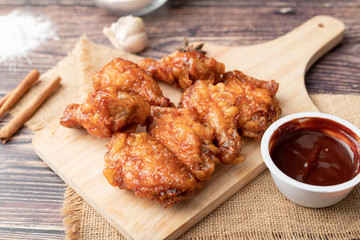 Hot and spicy Korean barbeque fried chicken on wood cutting board