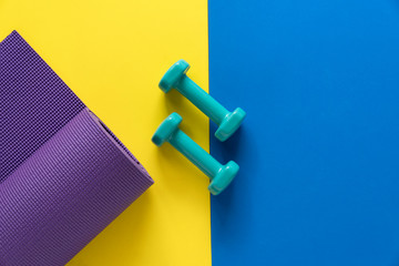 dumbbell and yoga mat on table, fitness healthy and sport concept
