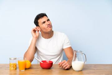 Handsome man in having breakfast having doubts and with confuse face expression