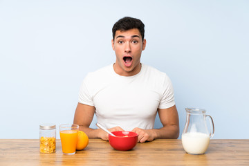 Handsome man in having breakfast with surprise facial expression
